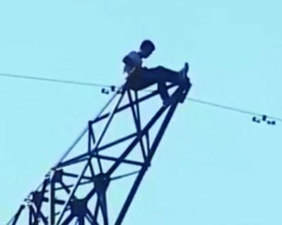 男子爬上高压线塔。