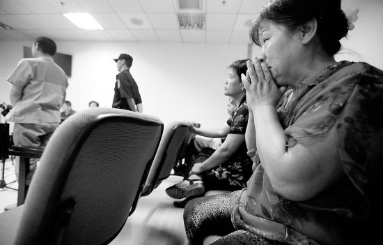 在法庭上,前来旁听的李某母亲(右一)忍不住捂脸大哭摄/记者曹博远