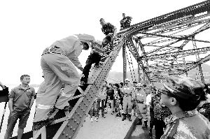 跳桥男子在消防人员的保护下下桥。本报首席记者 裴强 摄