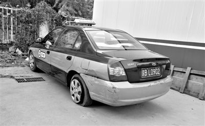 昨日，被撞爆胎的“克隆”出租车，停在朝阳交通支队奥运村大队院内。新京报记者 黄月 摄
