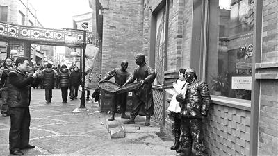 街头艺人扮成“铜人”热情地跟游客合影