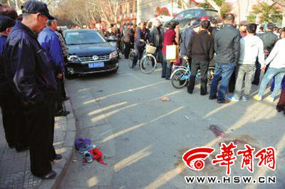 车祸现场的血迹被人用土覆盖，旁边则放着红领巾、一双童鞋和一顶帽子 本报记者 赵彬 摄