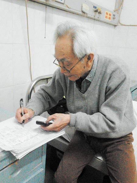 杜修源老人埋头写着特殊的“日记”。 李卓 摄