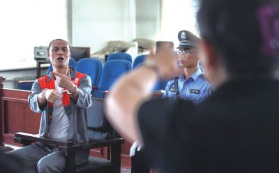 张志国在法庭上用手语回答提问。记者 蒲东峰摄