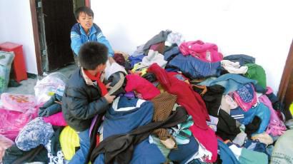 学生在帮忙整理收到的捐赠衣服。得石中心校供图