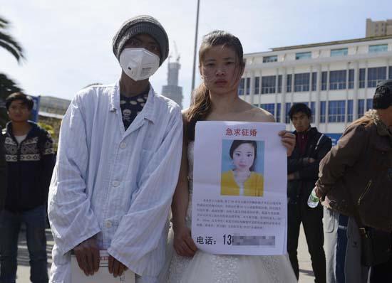 昆明火车站广场上，24岁的黄习菊身穿洁白的婚纱，带着身患白血病的弟弟征婚。