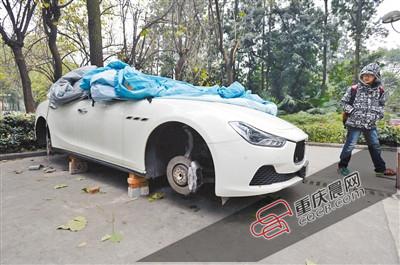 昨日，停放在重庆大学B区的一辆玛莎拉蒂豪车被架在几块砖头上，车轮不翼而飞。 重庆晨报记者 胡杰 摄