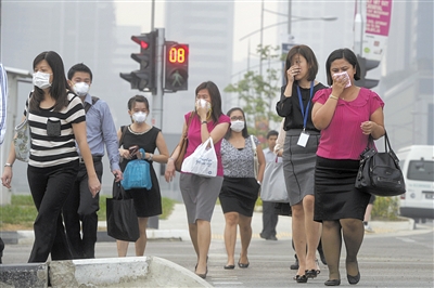 20日，正过马路的新加坡民众或戴口罩、或捂嘴。