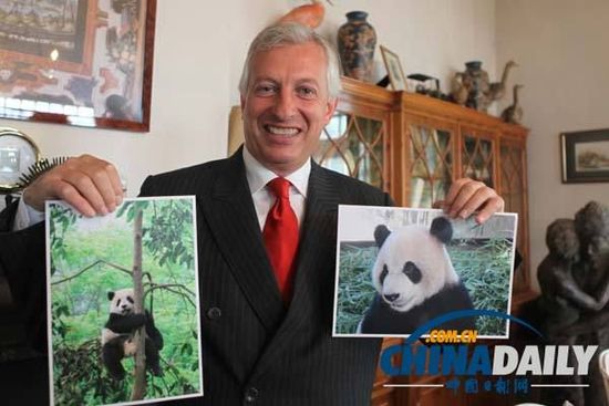 动物园的创始人兼主席埃里克展示熊猫星徽和好好的照片