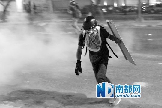 反政府示威者在与警察的冲突中躲避催泪弹。