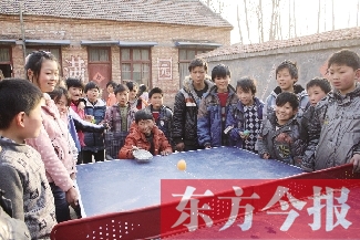 坐着轮椅的小宗成和同学们一块打乒乓球，这是他感到最快乐的事