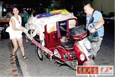 程亮和赵燕推着三轮拉货出摊