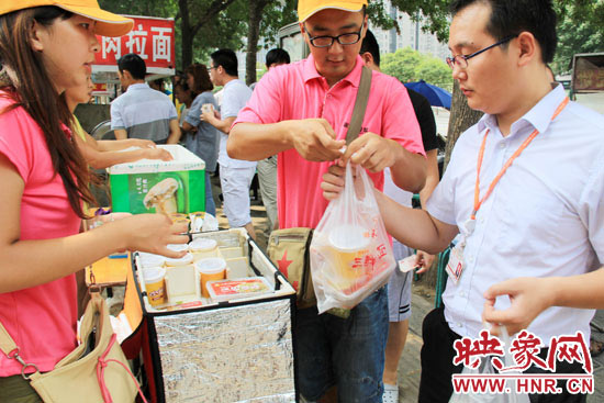 图为徐贵雨和一名勤工助学的学生在街头义卖快餐。