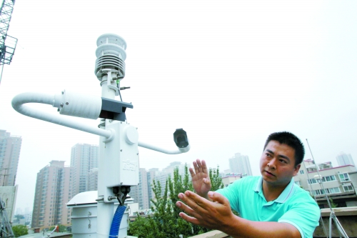 我省首个灰霾监测站预计月底在郑州正式投入使用，这是工作人员在介绍室外大气采集设备使用情况。（资料图）