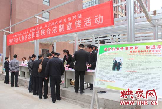 郑州市中院和郑州市妇联的工作人员在发放法律宣传手册，提供法律咨询服务
