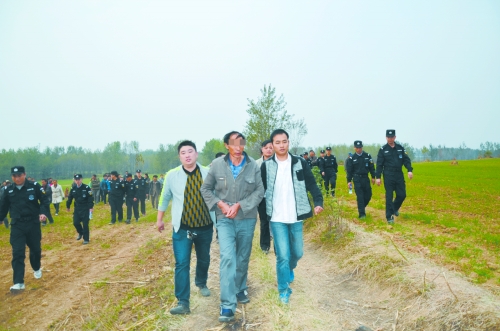 民警押犯罪嫌疑人指认现场