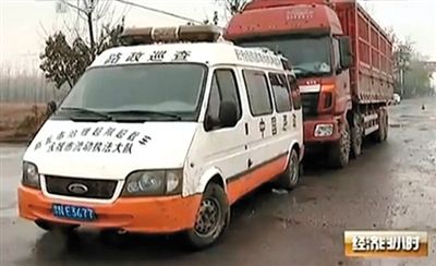 河南省永城市,一辆执法车挡在大货车前面。央视截图 河南省永城市,一辆执法车挡在大货车前面。央视截图