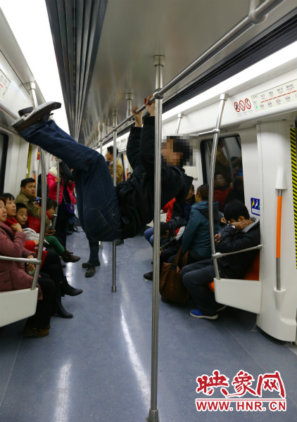 地铁试乘日，一男子在车厢内攀爬扶手自娱自乐