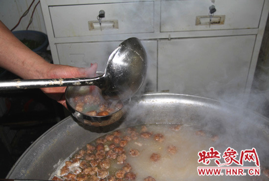 将煮好的丸子汤盛入放有食材的碗中