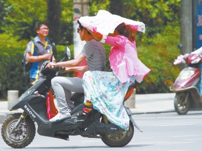 经三路与农业路口,行人撑起衣物遮阳。 经三路与农业路口,行人撑起衣物遮阳。