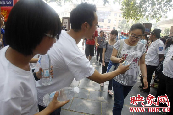 志愿者为刚刚考试完的考生送上1瓶冰冻的冰露·纯悦，消暑解渴为考生加油
