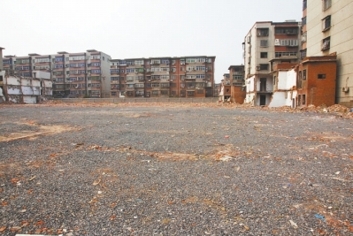 为降尘，旮旯王村拆迁后裸露的地面上铺了一层石子。