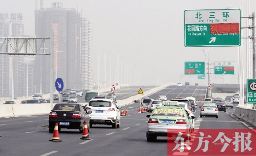 昨日，郑州市北三环高架桥上，指向国基路方向的指示路牌还用红布挡着