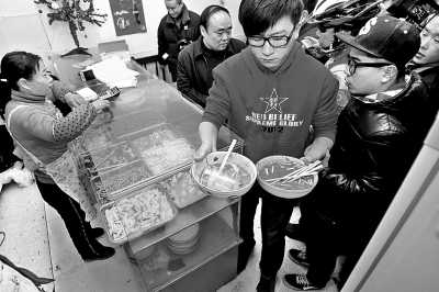 　　上图2013年年初，很多郑州市民光临李刚的面馆，掀起“全城吃面”热潮。CFP供图
