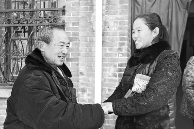 男童的爷爷紧握王新霞（右）的手，感谢她的帮助。
