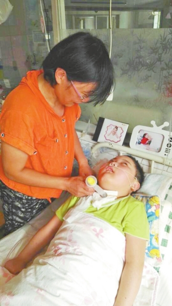 孙艺珊的母亲李玉玲正在照顾病床上的孩子