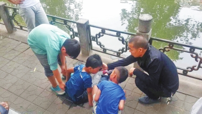男孩被救出后，围观群众帮他控水换衣服。