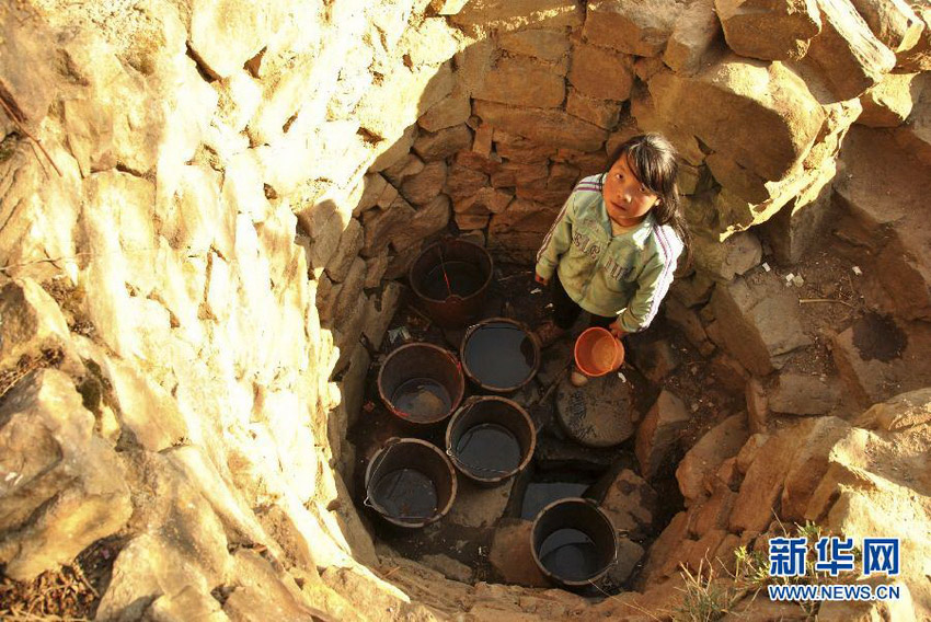 3月16日，在贵州省毕节市威宁县斗古乡水塘村，一名女孩在水量很少的井里取水。