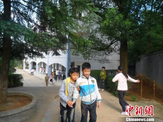 4年来，13岁的余兴泉（左一）每天都搀扶着腿脚不便的同学左臣进出教室、食堂和厕所。 李俊杰 摄