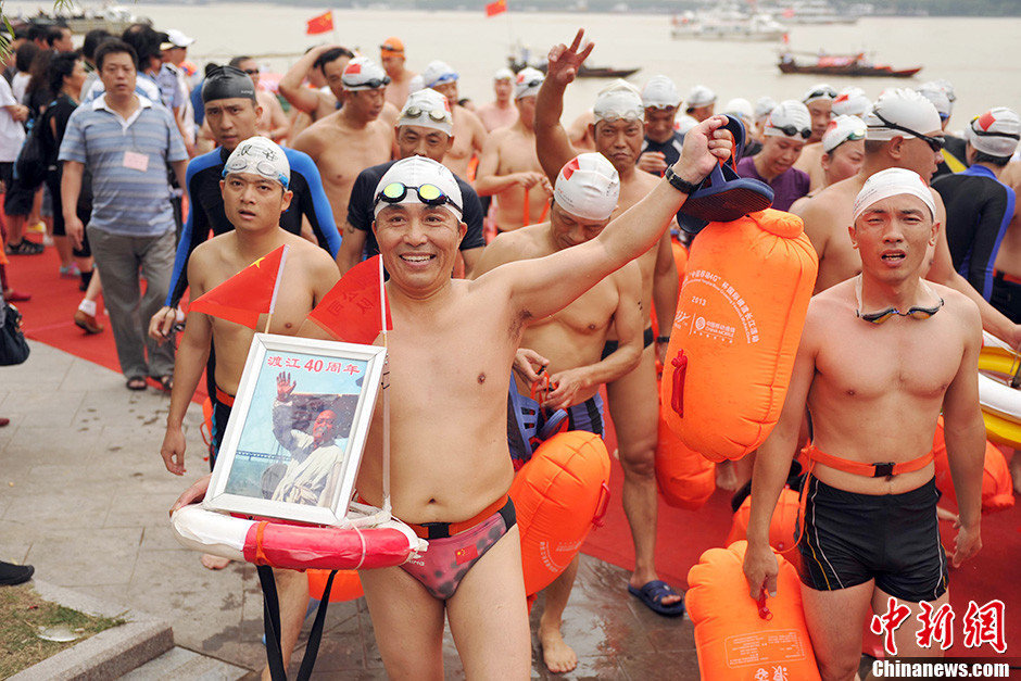 图为横渡方队的一位选手手举毛泽东画像。中新社发 张畅 摄