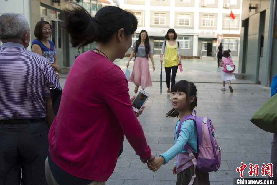 9月2日，一名一年级新生在校门口与家人告别。日前，随着开学季的到来，小学生减负问题再度引起关注。中新