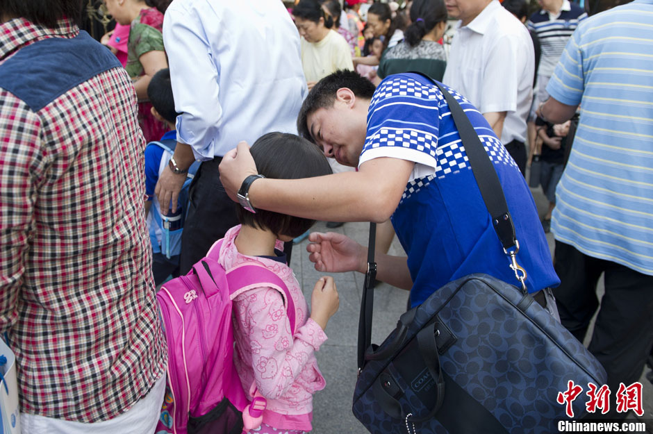 9月2日，一位家长正在安慰自己即将进入校园的孩子。中新社发 崔楠 摄