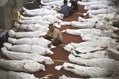 8月15日，在埃及首都开罗的一个清真寺，人们在成排的遗体旁哀悼。