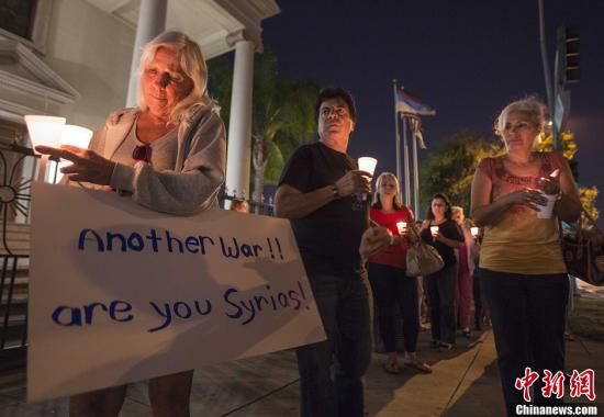 9月9日， 示威者手持蜡烛和海报出席烛光守夜活动。当天，在美国加利福尼亚州洛杉矶，民众抗议美国对叙利亚可能采取的军事行动，要求国会否决奥巴马的动武请求。中新社发 林戈 摄