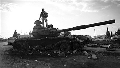 9月8日，叙利亚Zabadani，一名叙利亚反对派武装人员站在废弃的政府军坦克上。