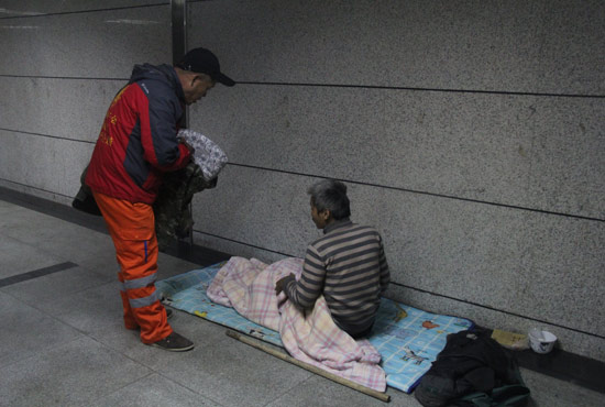 在郑州一处地下通道，孙德坤挑了几件衣服送给了流浪者