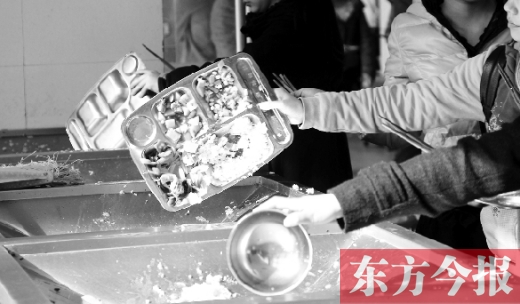 11月27日，河南中医学院餐厅，一名同学将餐盘内没吃完的食物倒入餐具回收车内