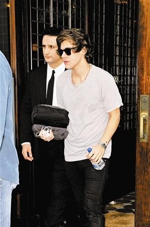 戴着墨镜的哈利被媒体发现后迅速离开酒店