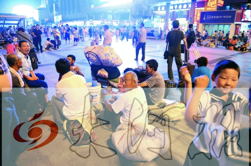 记者昨晚在郑州火车站东广场看到不少候车乘客席地而坐