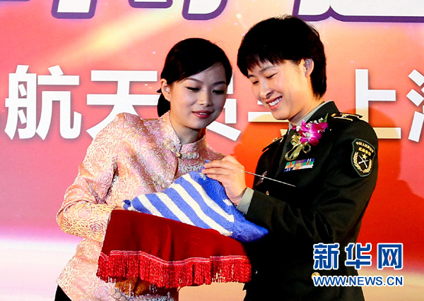 11月1日，航天员刘洋（右）在为“爱心”毛衣编织最后的收尾针。