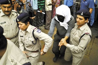 16日，印度中央邦，被轮奸的瑞士女游客（中）在警方陪同下前往医院检查。