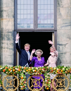4月30日，荷兰国王威廉-亚历山大（左）和王后马克西玛（右）与前任女王贝娅特丽克丝（中）在阿姆斯特丹皇宫阳台上向民众挥手致意。新华社发