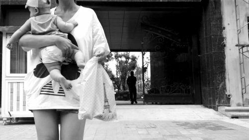 抱着孩子出售人奶的女子。