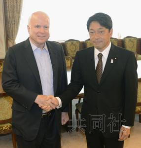 21日上午，美国共和党资深参议员麦凯恩（左）与日本防卫相小野寺在防卫省会谈前握手。（图片来源：日本共