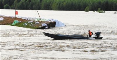 昨日，一艘搜救艇穿越堤坝决口进入村中巡查。当日，黑龙江堤防八岔段决口200米。新华社发