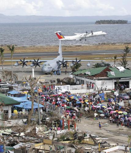 13日，在菲律宾遭受台风“海燕”袭击灾情最严重的莱特省塔克洛班市，灾民在机场外等待离开。